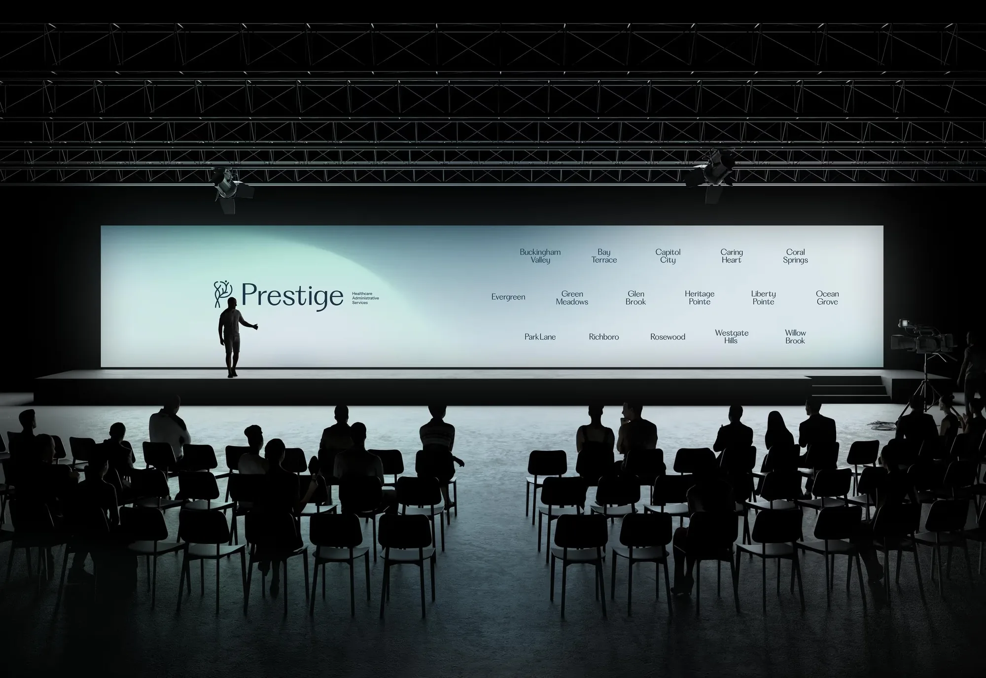 Prestige Healthcare — the facility network wall on an event stage, audience in silhouette